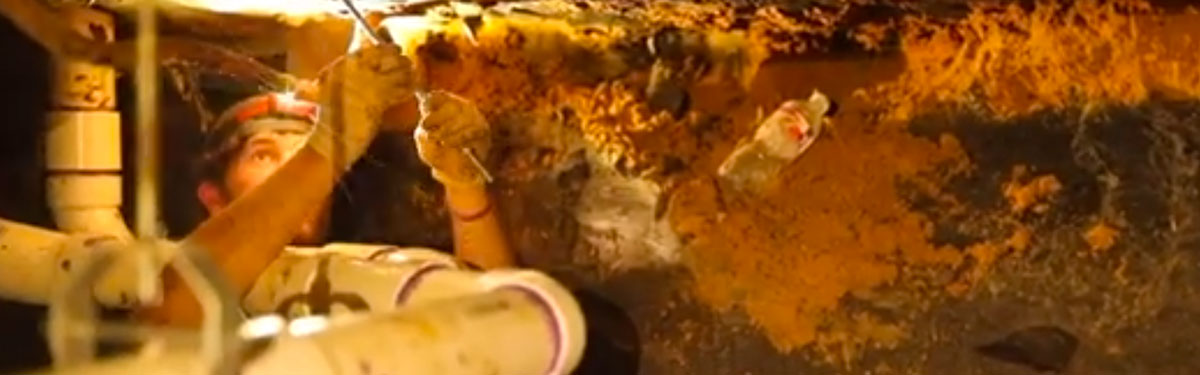 Plumber working underground on the sewer line piping