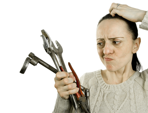 confused look while holding tools